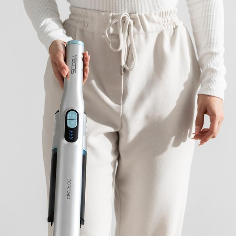 Cecotec Scoba 2100 Jalisco upright vacuum, silver and blue, held by a person wearing white clothes.