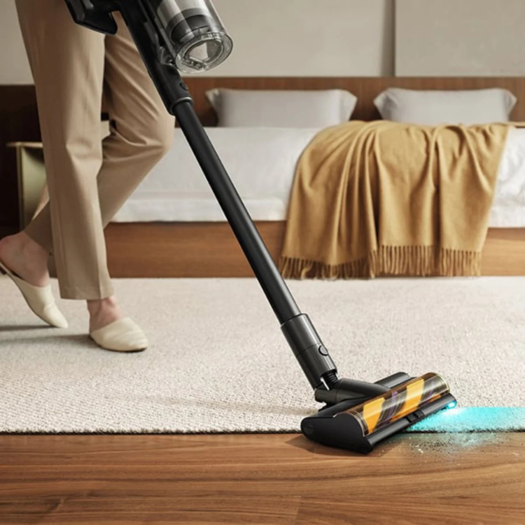 Black cordless Dreame Z20 vacuum on hardwood floor with blue light on.