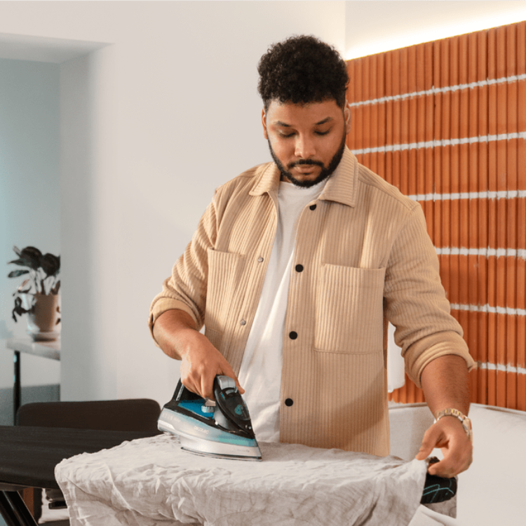 Cecotec IronHero 2600 Force steam iron, man ironing white fabric.