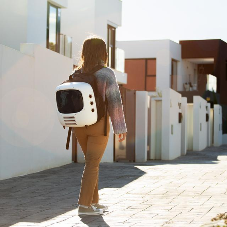 Woman carrying white Cecotec Pumba 1800 pet carrier on back.