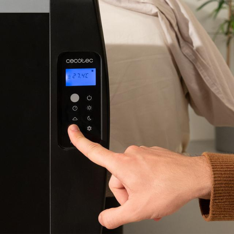 Black Cecotec Ready Warm 2500 Thermal heater control panel with blue display and buttons, finger pressing button.