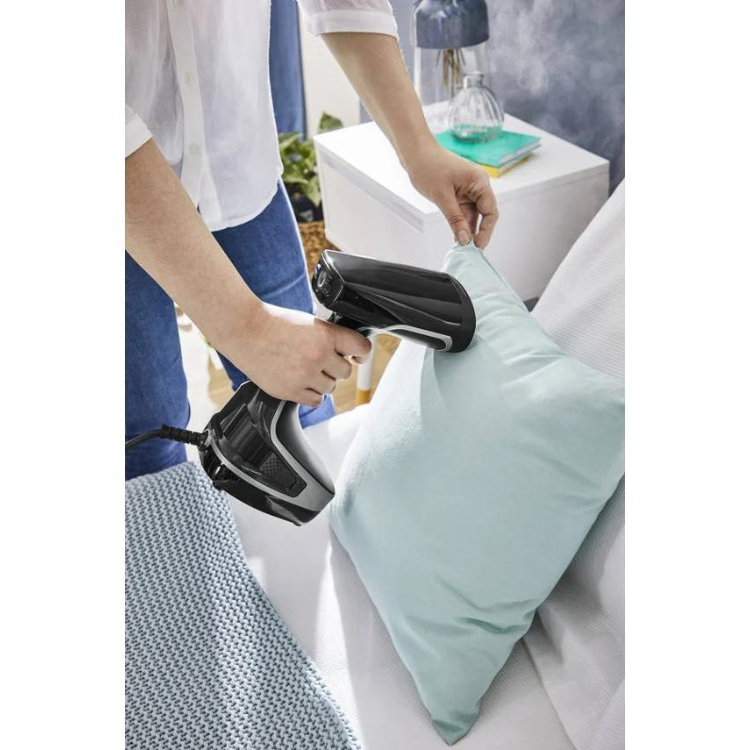 Black and grey Rowenta steam iron on a light blue pillow.