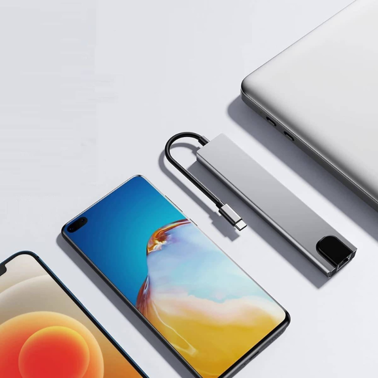 Ewent EW1146 8-Port USB-C hub in grey, with USB-C connector and cable, next to laptop and smartphones.