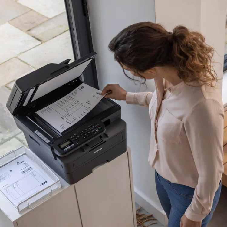 Black Brother MFC-L2800DW laser multifunction printer with Wi-Fi on white surface.