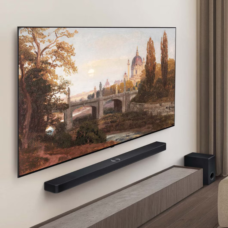 TV LG OLED 48" 4K, montada na parede com soundbar e subwoofer, a exibir paisagem natural.