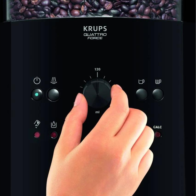 Black Krups Quattro Force coffee machine control panel with hand adjusting settings, coffee beans visible at top.