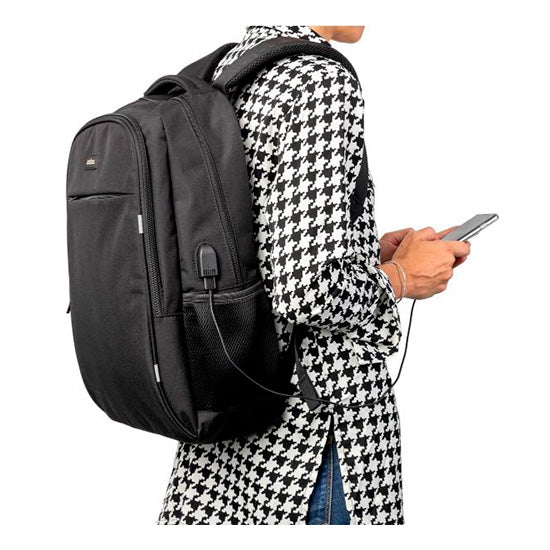 Mochila Nilox 15.6" Style preta usada nas costas de uma pessoa com casaco preto e branco.