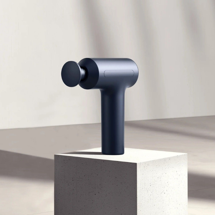 Xiaomi Massage Gun 2, black massage gun on a concrete block.